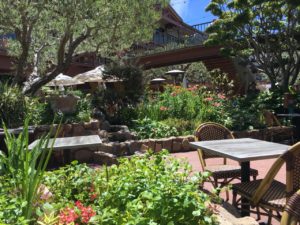 Outdoor tables among the gardens in the plaza.