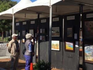 Viewers admiring the paintings.